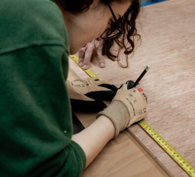 An image showing a person taking measurements in a workshop