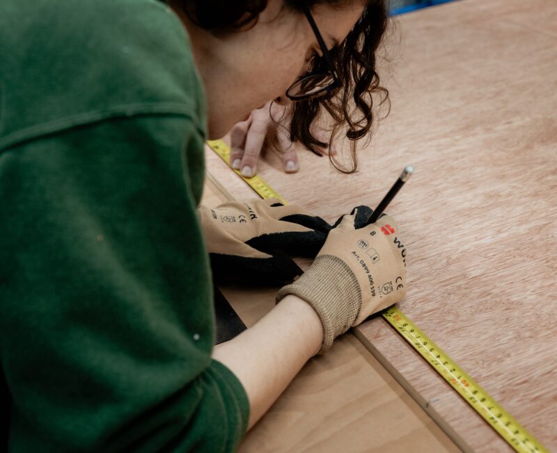 An image showing a person taking measurements in a workshop