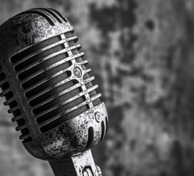 A black and white image showing a vintage microphone