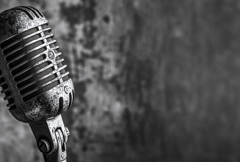 A black and white image showing a vintage microphone