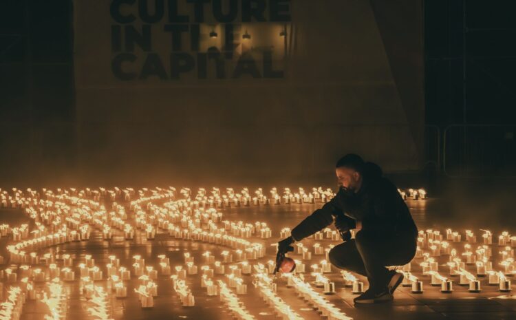 A photo showing a man lighting up one of the hundreds of firebowls making up the Holy Week installation in St George's Square, Valletta